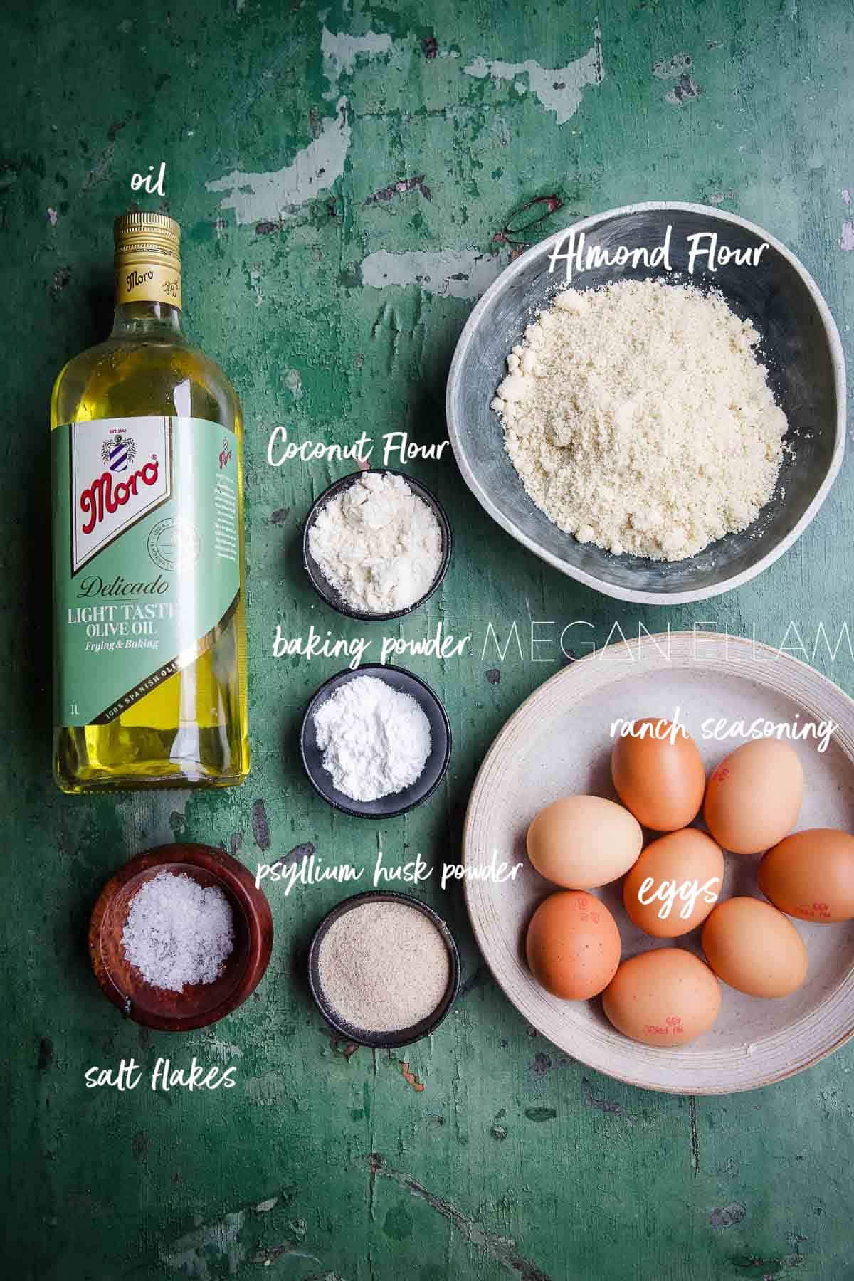 The Best Keto Bread Recipe ingredients all laid out and labelled on a green backdrop.
