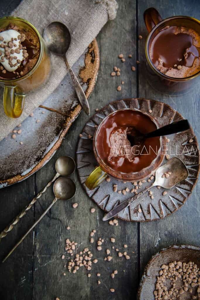 Three glasses of chocolate low carb mousse on a wood table.